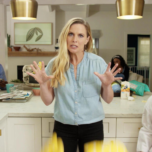 Woman in kitchen with nut-free snack bars on counter, promoting allergy-friendly No Nuts bars