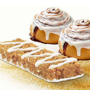 Nut-free cinnamon roll snack bar with icing, two cinnamon rolls in background, allergy-friendly