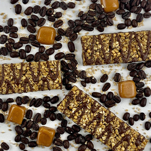 Nut-free snack bars with chocolate drizzle, coffee beans, and caramel squares on white background