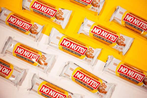 No Nuts nut-free snack bars with lemon creme flavor on yellow and white background, allergy-friendly