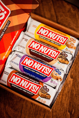 Box of No Nuts nut-free snack bars in assorted flavors on wooden table