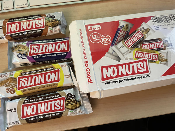 No Nuts! nut-free protein snack bars and packaging on a wooden desk