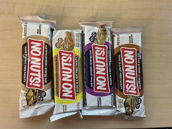 No Nuts nut-free snack bars assorted flavors on wooden table, allergy-friendly packaging