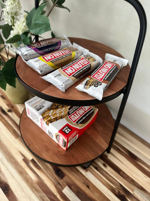 No Nuts nut-free snack bars on a wooden shelf with a No Nuts box and decorative plant