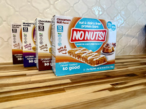 No Nuts nut-free snack bars in assorted flavors on a wood counter, allergy-friendly packaging