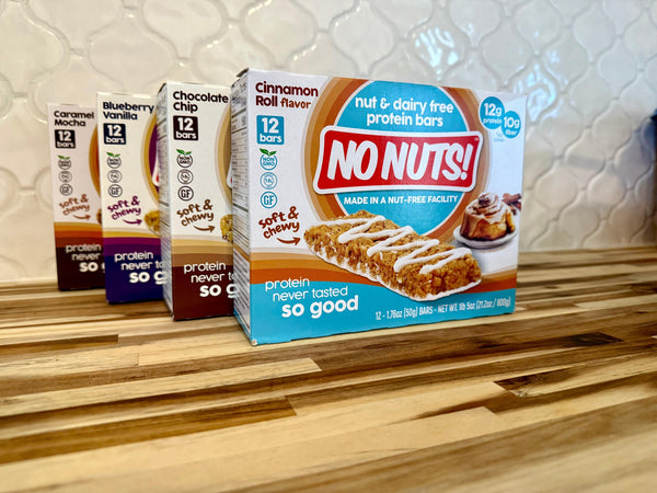 No Nuts nut-free protein bars in assorted flavors on kitchen counter, allergy-friendly packaging