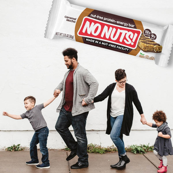 Happy family walking on sidewalk below No Nuts nut-free snack bar, allergy-friendly food