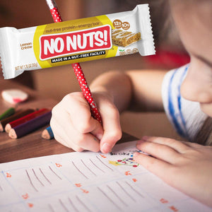 Child drawing at desk with No Nuts! nut-free snack bar, school-safe and allergy-friendly.