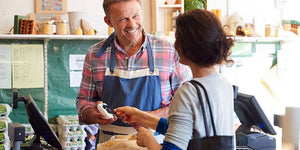 Smiling clerk helps customer at register in nut-free snack store