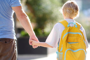 Child with yellow backpack holding adult's hand, back to school, allergy-friendly snacks