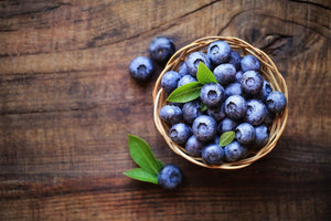 Fresh blueberries in a wicker basket on a rustic wood table, nut-free snack ingredient