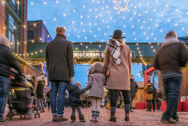 Family at outdoor festive market under string lights, ideal for allergy-friendly No Nuts bars