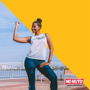 Smiling woman in workout gear flexes arm outdoors, No Nuts! nut-free snack bars logo bottom right.