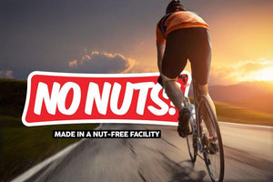 Cyclist riding on road at sunset with No Nuts! nut-free snack bars logo overlay