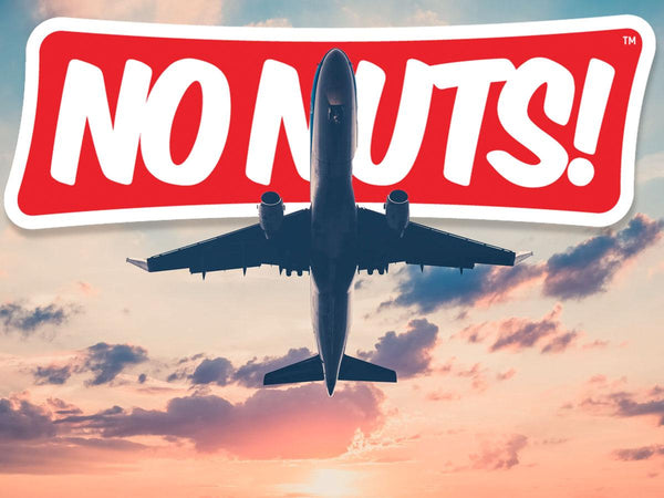 Airplane flying at sunset with large No Nuts! nut-free snack bars logo above