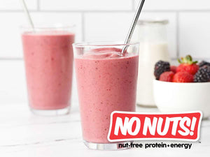 Nut-free berry smoothie in a glass with metal straw, fresh berries, and No Nuts branding