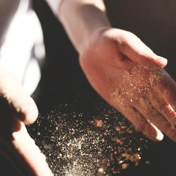 Hands dusted with flour, highlighting baking nut-free snack bars in natural light
