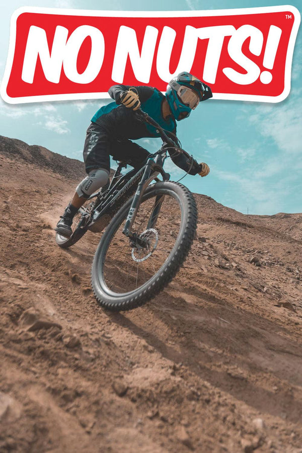 Mountain biker riding on rocky trail under No Nuts! allergy-friendly snack bars logo