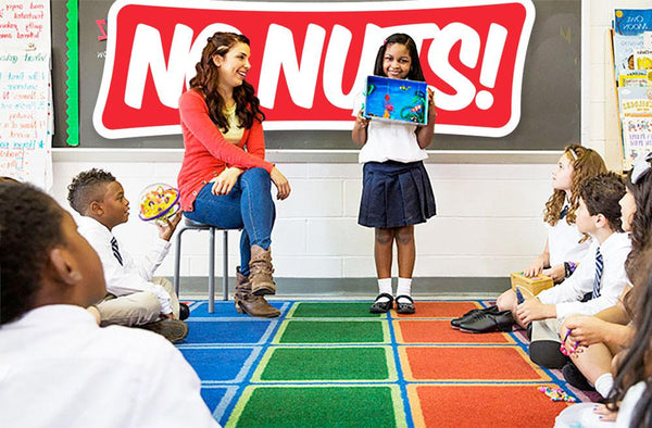 School classroom with teacher and children, large 'No Nuts!' sign for nut-free snacks