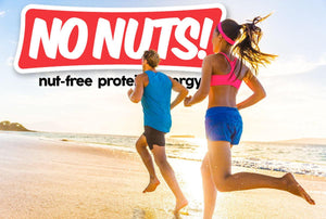 Two people running on a beach with large No Nuts! nut-free protein energy bar logo in background