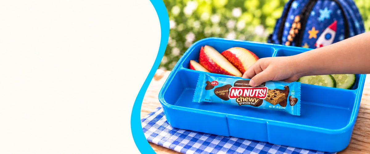 Child's hand picking a No Nuts! chewy chocolate chip nut-free granola bar from a blue school lunchbox